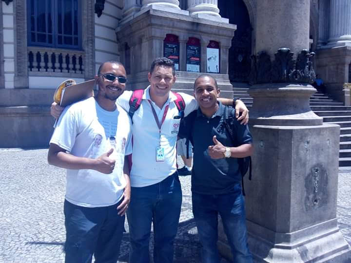 Três amigos do grupo Acabou a Brincadeira de Guadalupe, que se encontraram casualmente, em plena Praça Floriano (Cinelândia), no Centro da Cidade do Rio de Janeiro; ao fundo da imagem: o Teatro Municipal. (foto 3)